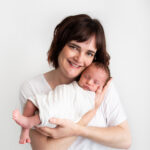 Posed mother and newborn baby wearing white