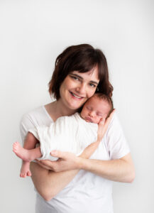 Posed mother and newborn baby wearing white